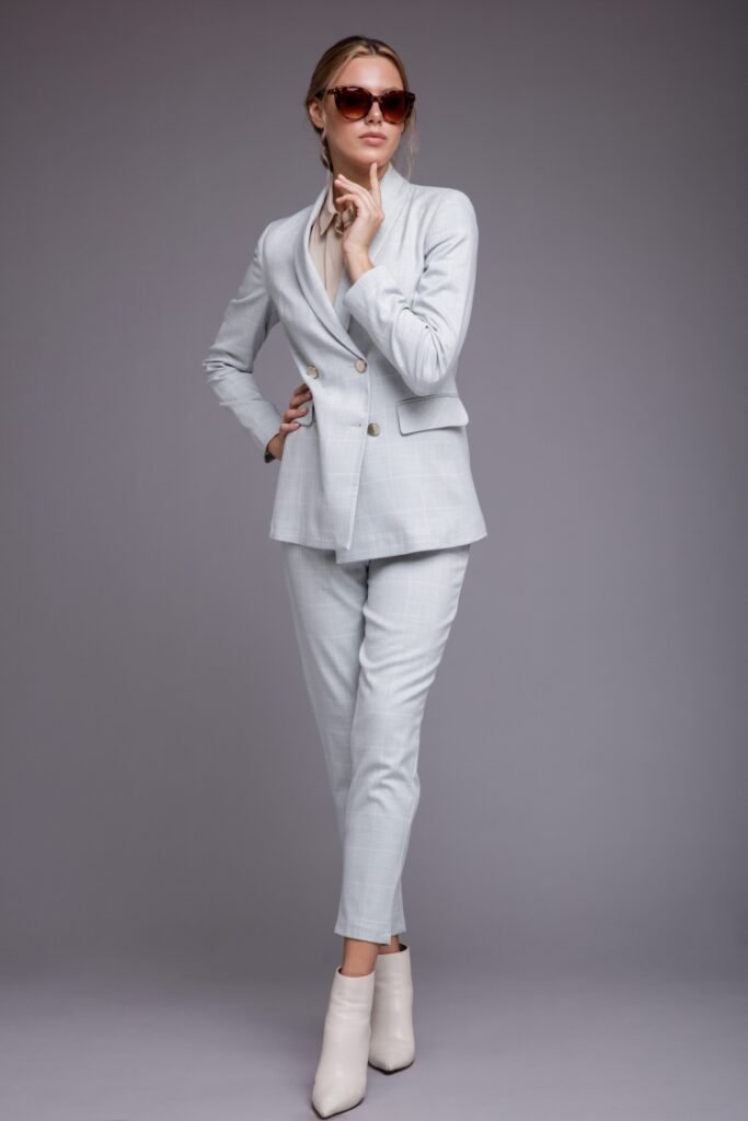 woman-soft-blue-suit-jacket-pants-sunglasses-gray-background-studio-shot-monochrome-colors