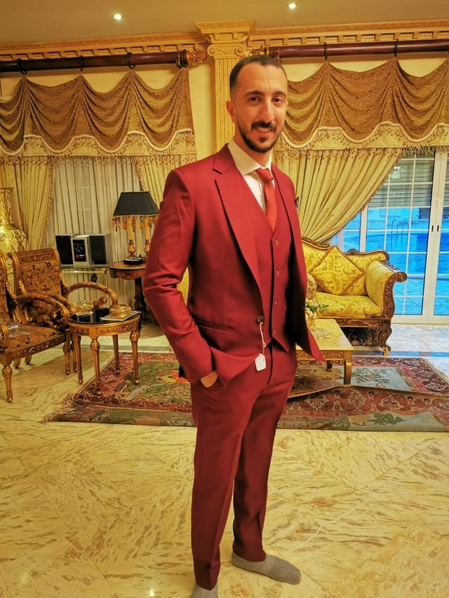 A man dressed in a red color suit