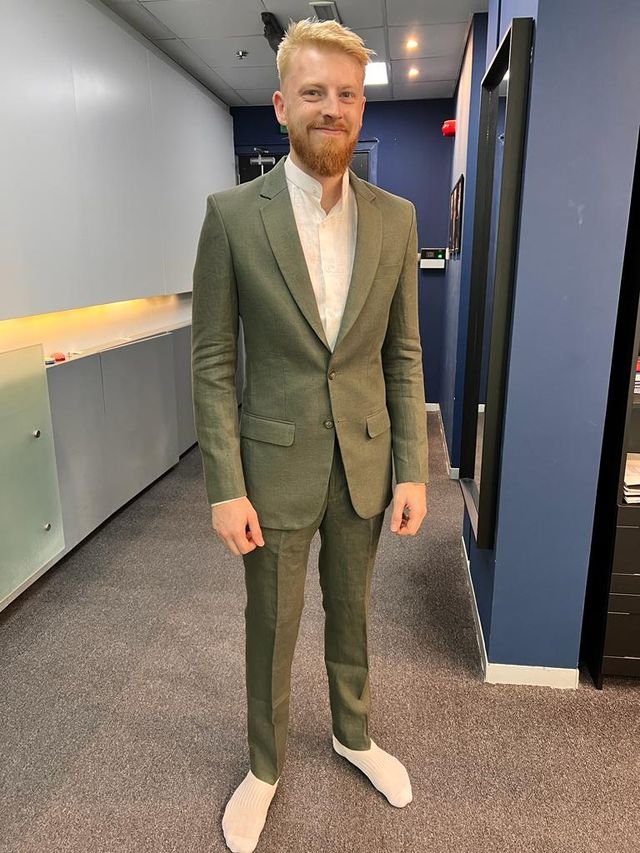 A man dressed in a olive green suit