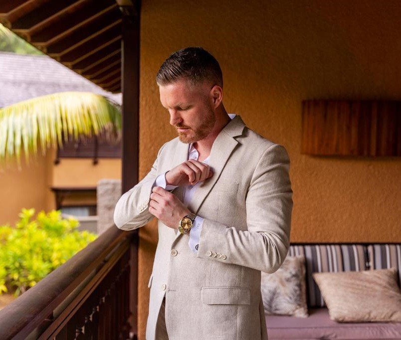 A man dressed in a beige color suit