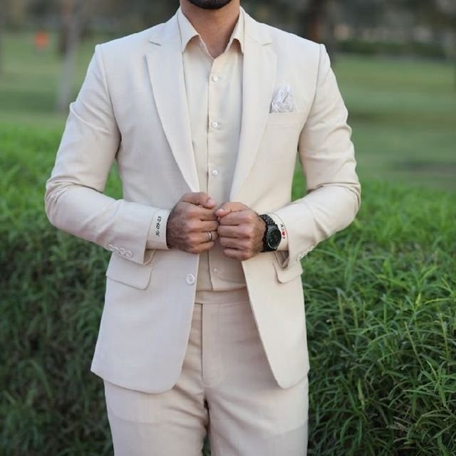 A man dressed in a beige color suit