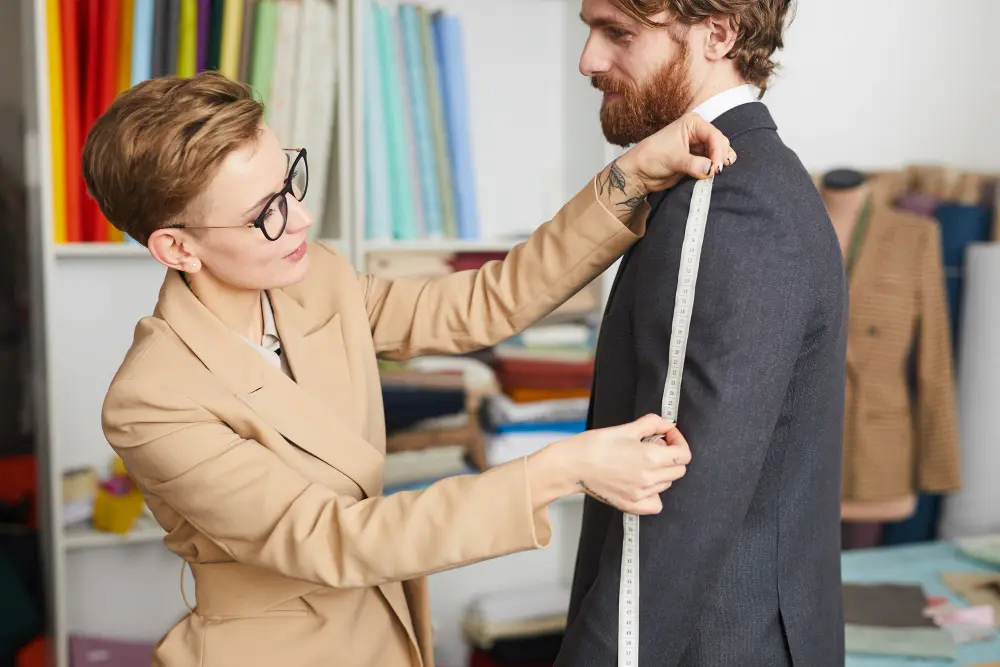 Young professional being fitted for a custom business suit by a London bespoke tailor