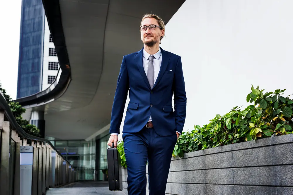 A senior executive wearing a perfectly tailored navy bespoke suit in a modern London office overlooking the city skyline.